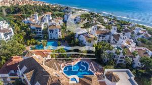 an aerial view of a resort with a pool and the ocean at Jardines de las Golondrinas in Marbella