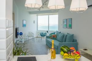 a living room with a blue couch and a table with fruit at Luxury Penthouse 1BR-Seafront-Seasonal Pool-Central in Larnaca