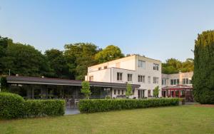 un edificio con césped delante en Parkhotel De Bosrand en Ede