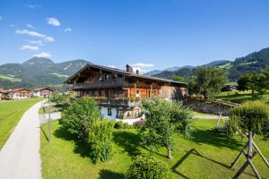 ein Haus mitten auf einem grünen Feld in der Unterkunft Schwarzenbergerhof in Reith im Alpbachtal