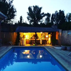 a swimming pool in a backyard at night with a house at Renacer de los Sentidos in Pelayos de la Presa