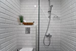 a white bathroom with a shower and a toilet at Adel Apartments in Veliko Tŭrnovo +35 photos