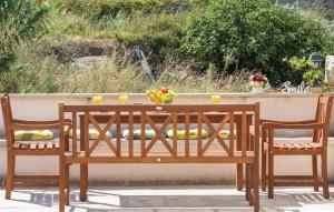 een houten tafel met 2 stoelen en een fruitschaal bij Vacation apartments Feniks in Tučepi