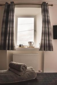 una ventana con cortinas y una toalla en un radiador en THE BRUCE en Bowmore