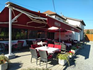 ein Restaurant mit Tischen und Stühlen auf einer Terrasse in der Unterkunft Pansion Ribnjak in Našice