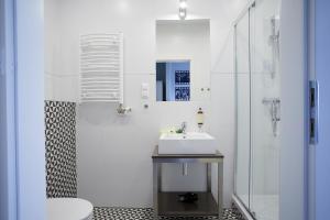 biała łazienka z umywalką i prysznicem w obiekcie FLORIANSKA 32 by PI Apartments w Krakowie
