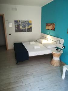een slaapkamer met een groot bed met een blauwe muur bij Piazza Castello in Santo Stefano Quisquina