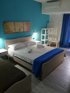 een slaapkamer met een groot bed met een blauwe muur bij Piazza Castello in Santo Stefano Quisquina
