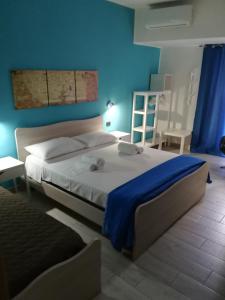 a bedroom with a large bed with a blue wall at Piazza Castello in Santo Stefano Quisquina