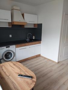 a kitchen with a table and a washing machine at Apartament Pogodno in Szczecin