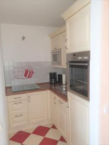 a kitchen with white cabinets and a red and white floor at Ferienwohnung Lieblingsort im Zentrum Winterbergs in Winterberg