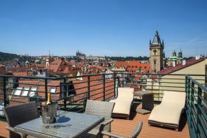 a patio area with chairs, tables, and tables with umbrellas at Hotel Leon D´Oro in Prague