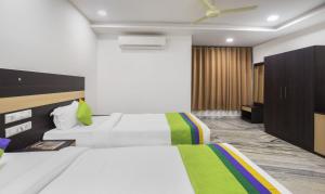 a hotel room with two beds and a ceiling fan at Hotel Royal Dezire Udaipur in Udaipur