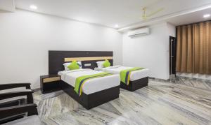 a hotel room with two beds and chairs at Hotel Royal Dezire Udaipur in Udaipur