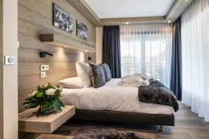 a bedroom with a large bed and a window at Canyon Lodge by Alpine Resorts in Saint-Bon-Tarentaise