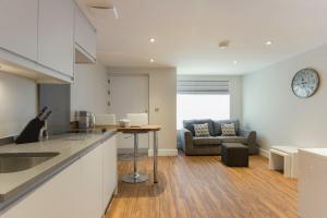 a kitchen and living room with a table and a couch at Citystay - The Dales in Cambridge