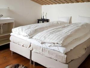 a bedroom with a bed with white sheets on it at Four-Bedroom Holiday home in Jelsa 2 in Jelsa