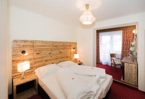 a bedroom with a large bed with a wooden headboard at König - Joker Card included in Summer in Saalbach-Hinterglemm