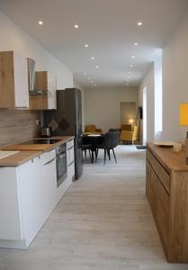 a kitchen with white cabinets and a living room at La Maison de Jules in Paray-le-Monial