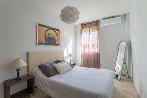 a bedroom with a white bed and a window at Granada Albaicín Aynadamar in Granada