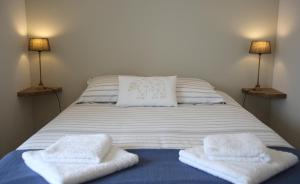 a bed with two towels on it with two lamps at La Maison de Jules in Paray-le-Monial