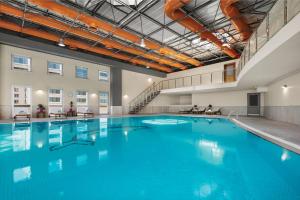 a large swimming pool with blue water in a building at Wyndham Grand Kayseri in Kayseri