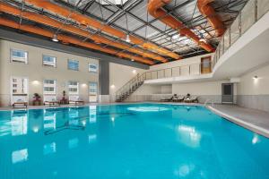 ein großer Pool mit blauem Wasser in einem Gebäude in der Unterkunft Wyndham Grand Kayseri in Kayseri