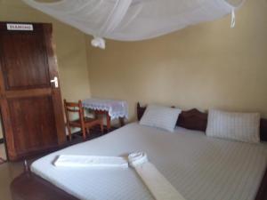 a bedroom with a bed with a canopy and a chair at Jfour comfort zone hostel in Dar es Salaam