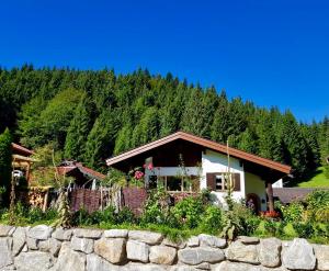 a house in the mountains with a stone wall at Ferienhaus Ursula in Klais