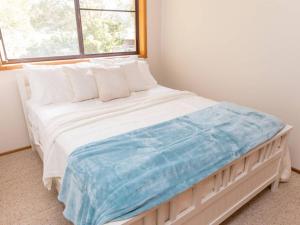 a bedroom with a large bed with a window at Kookas Nest - waterfront home, tranquil setting in Dunbogan