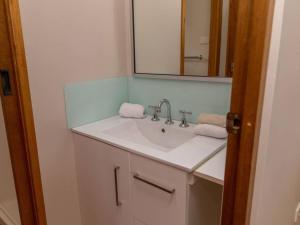 a bathroom with a sink and a mirror at Kookas Nest - waterfront home, tranquil setting in Dunbogan