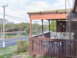 a porch of a house with a view of a river at Kookas Nest - waterfront home, tranquil setting in Dunbogan