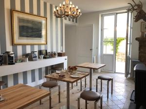 a dining room with two tables and chairs and a chandelier at Château Bernon Maison d Hotes - Piscine et sauna in Queyrac