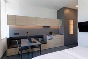 a room with a kitchen and a table with a laptop at TT-ROOMS - kontaktlos mit Self Check-in I FREE PARKING in Graz