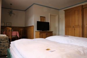 a hotel room with two beds and a flat screen tv at Gästehaus Blaue Ecke in Adenau +28 photos