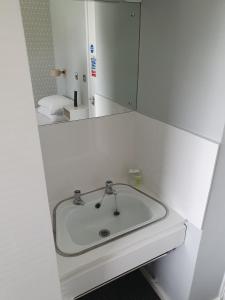 La salle de bains est pourvue d'un lavabo blanc et d'un miroir. dans l'établissement The Derby Conference Centre - Shared Accomodation, à Derby