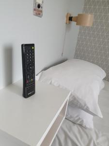 a remote control sitting on a white table next to a bed at The Derby Conference Centre - Shared Accomodation in Derby