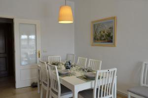 una sala da pranzo bianca con tavolo e sedie bianchi di PLAZA ALFONSO SÁNCHEZ FERRAJÓN a Jerez de la Frontera Altre 13 foto