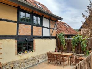 una casa con una mesa de madera y sillas en un patio en Villa Windschief, en Thale