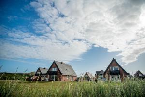 una fila de casas en un campo bajo un cielo nublado en Ferienzentrum Wenningstedt en Wenningstedt