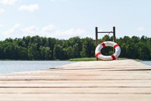 a wooden pier with a life preserver on the water at Canow in Canow