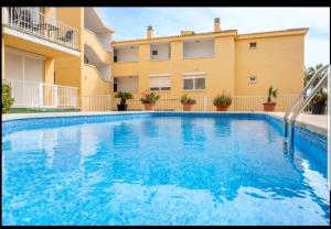 a swimming pool with a slide in front of a building at Ronda Playa in Can Picafort