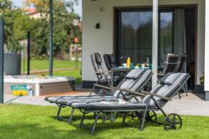 a group of lawn chairs sitting on the grass at Luxus_SPA_EG_Fewo AQUAMARIN _WE 1_ in Göhren-Lebbin