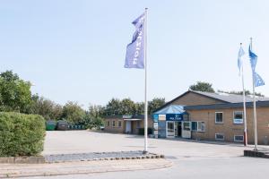 two flags on a pole in front of a building at Pulzion - Sportshotel in Kolding