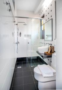 a bathroom with a shower and a toilet and a sink at Areca Hotel Penang in George Town