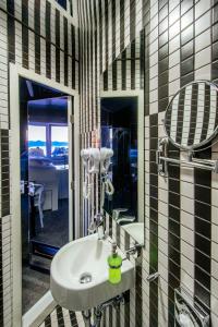 ein Bad mit einem Waschbecken und einem Spiegel in der Unterkunft Boutique Hostel Forum in Zadar
