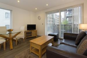 a living room with a couch and a table at Citystay - Mill Park Apartments in Cambridge