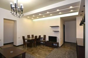 a dining room with a table and chairs and a television at Rent Inn Yerevan on Sakharov Square in Yerevan