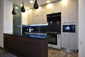 a kitchen with a black counter top and wooden cabinets at Rent Inn Yerevan on Sakharov Square in Yerevan