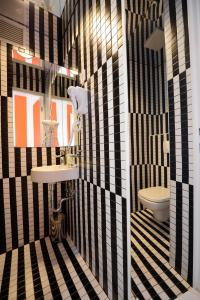a bathroom with a black and white tiled wall at Boutique Hostel Forum in Zadar +24 photos